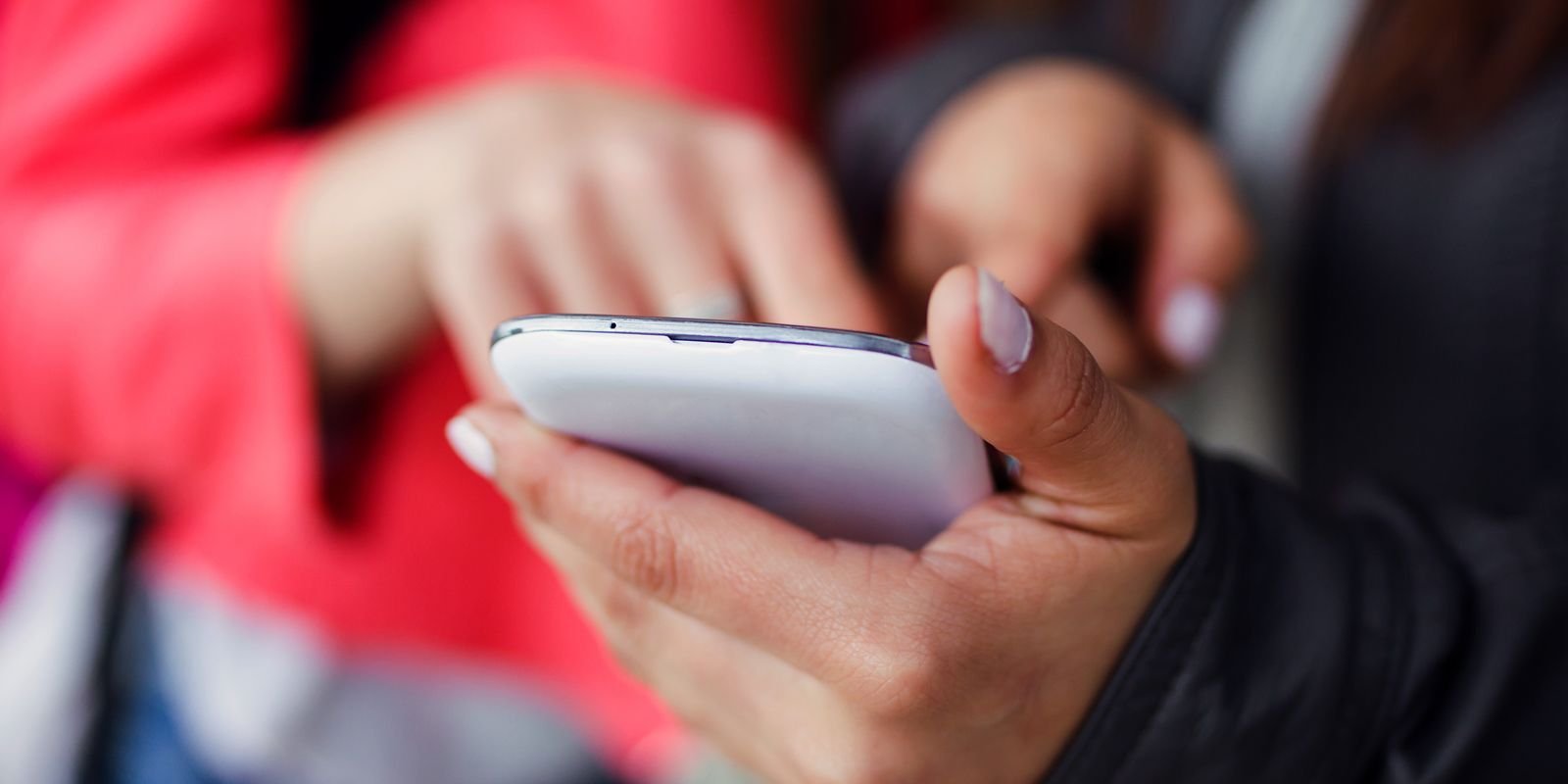 two beautiful students using mobile phone street 0.jpg